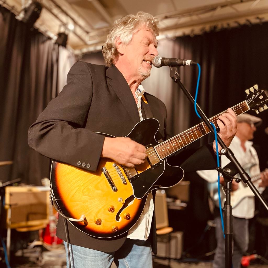 Musiker fra The Hicks med guitar og mikrofon