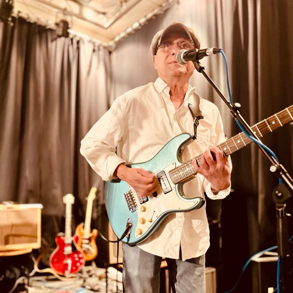 Musiker fra The Hicks med guitar ved mikrofonen
